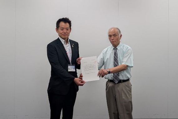 市長から下水道事業審議会会長への諮問。市長と審議会会長が並び、2人で諮問書を持っている様子。