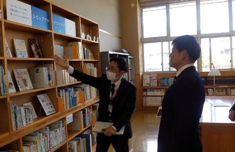 山東図書館の視察風景。本棚に向かって説明している職員と市長の写真