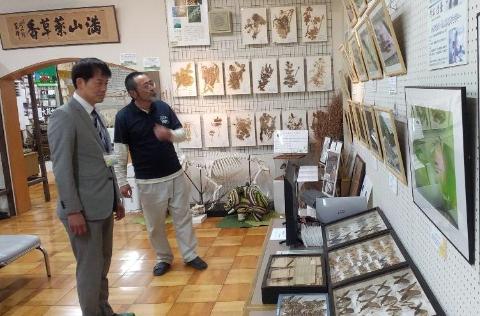 伊吹山文化資料館視察風景。多くの資料物を前に説明されている職員と市長の写真