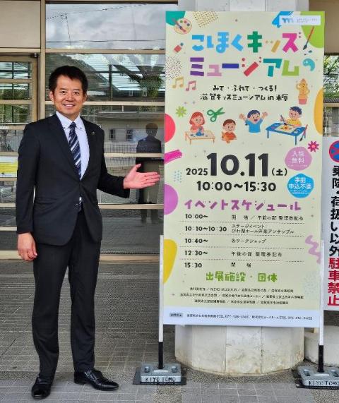 こほくキッズミュージアムの看板を横に祈念撮影をされている市長の写真