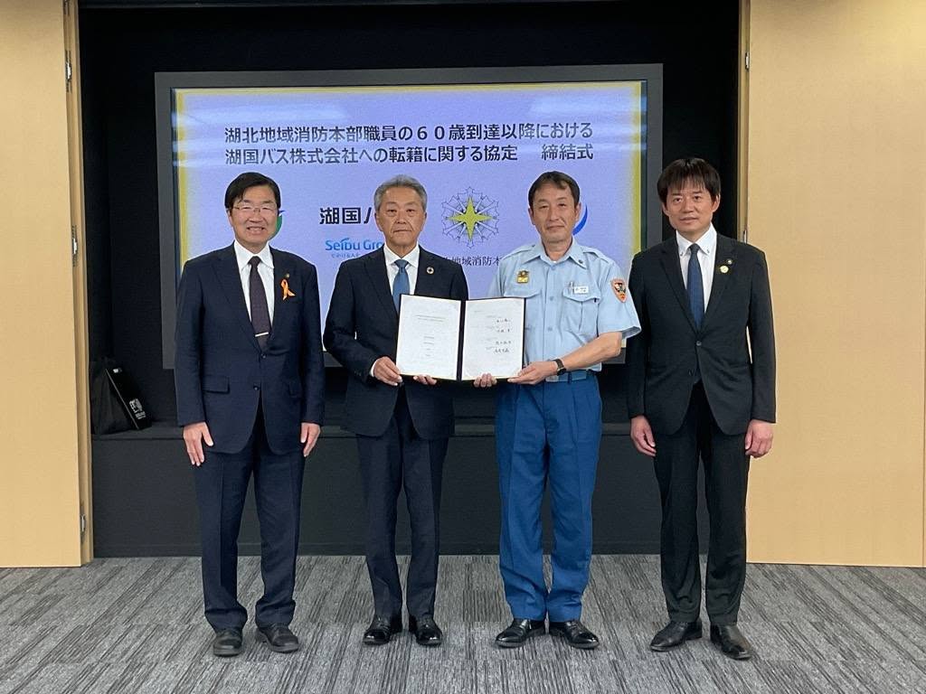左から、スーツを着た職員2人、そのうち1人と協定書を手に持っている消防署職員の方。その横には市長が立っている写真