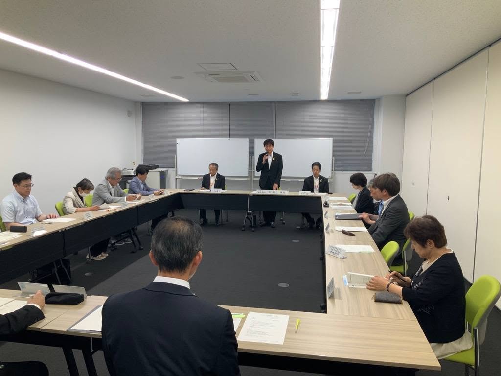 会議室にて、マイクを手に持ち立って意見を述べている市長の写真