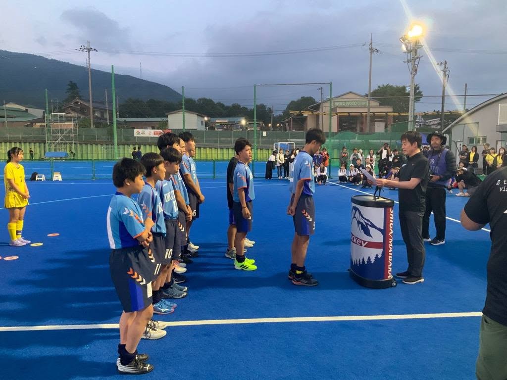 中学生男子チームの選手たちに表彰しているようすの写真