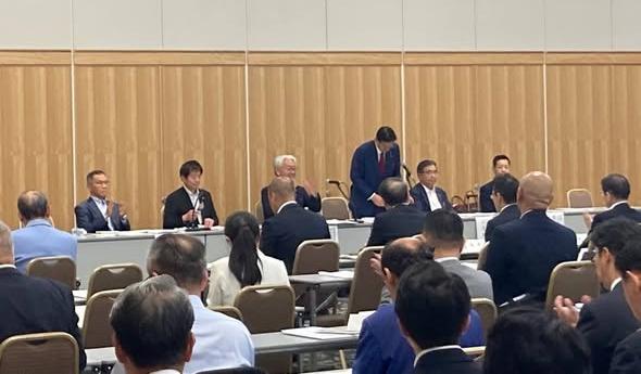 会議室にて、長机が並んでおり、大勢の人が出席されているようすの写真