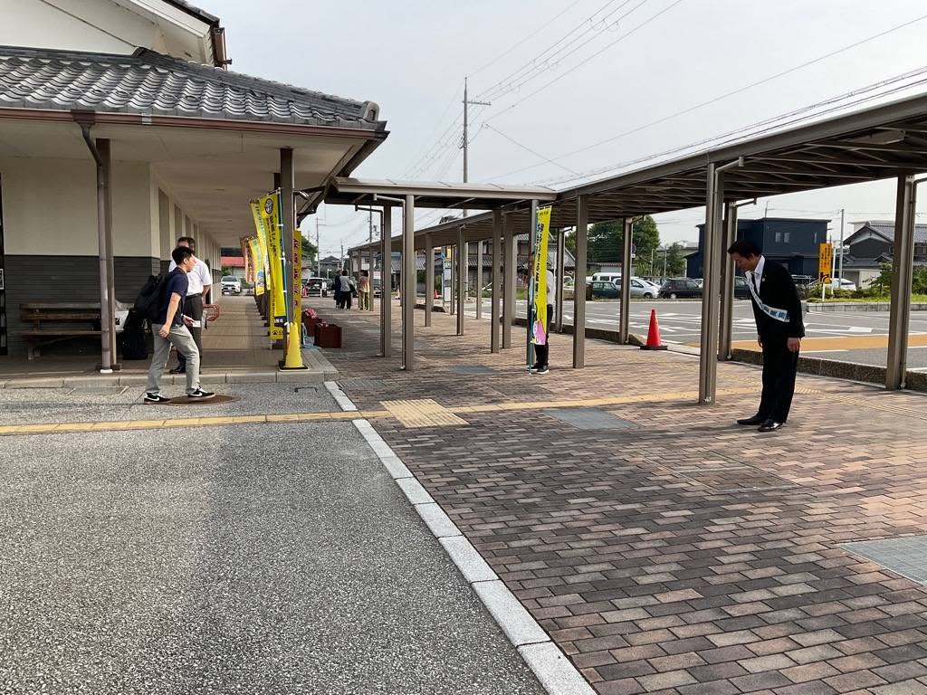 坂田駅前のロータリー周辺で市民にあいさつ運動を行う市長の写真