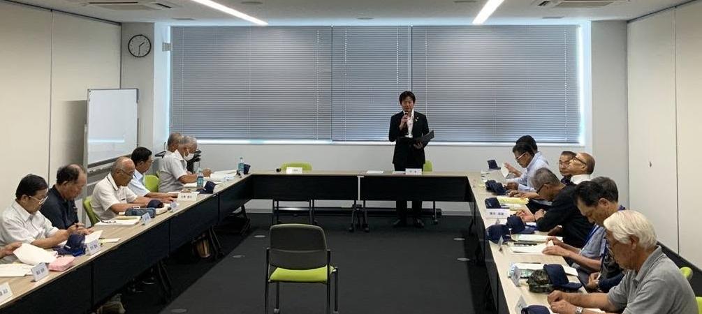 会議室にて、長机で囲み、窓際あたりの席から立ってお話されている市長の写真
