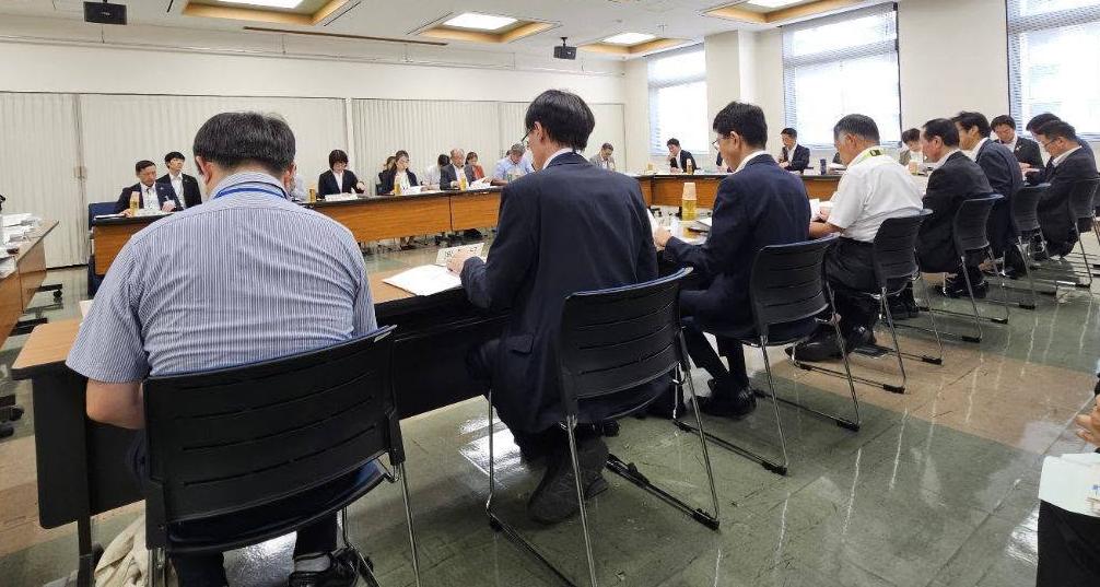 会議室にて、長机で囲んで会議しているようす