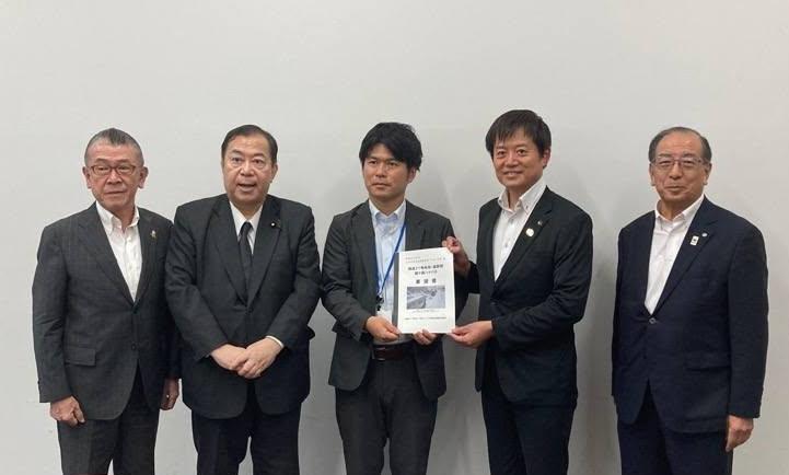 男性5人が集まって撮影。右から2番目にいる市長と、その横に立っている男性と要望書を手に持っている写真。