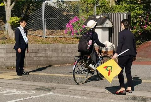 5月のあいさつ運動。自転車に乗って通学している生徒に挨拶されている市長の写真
