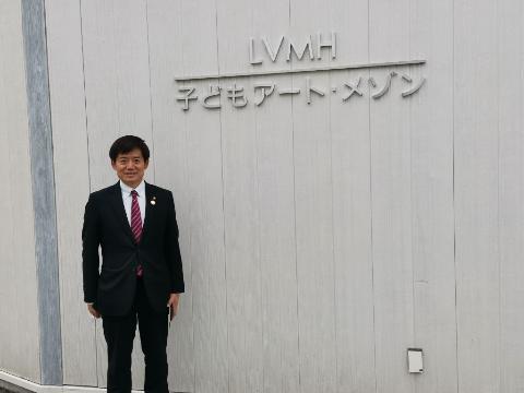 LVMH子どもアート・メゾンを視察いたしました。LVMH子どもアート・メゾンのロゴの前に立って写真撮影