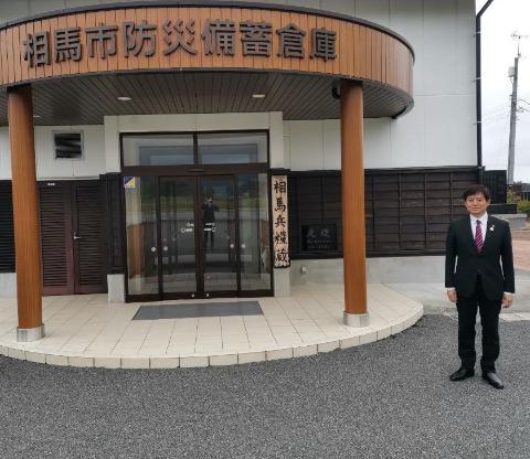 視察の様子。相馬市防災備蓄倉庫の出入り口にて写真撮影