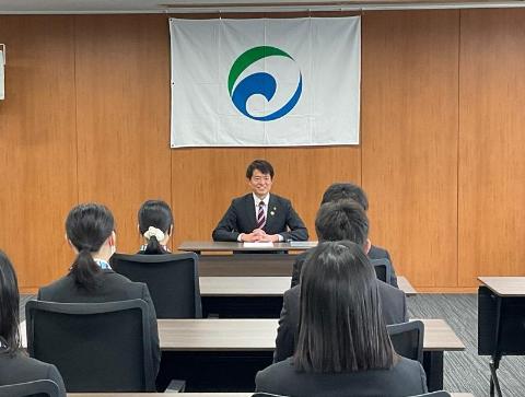 新規採用職員の皆さんの前に市長が笑顔で話されているようす