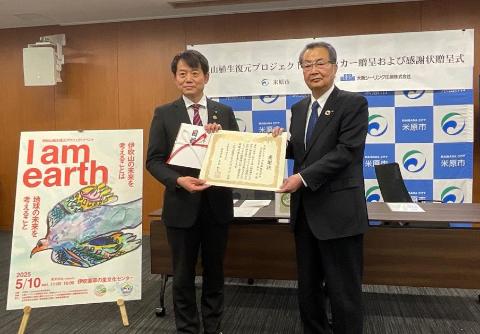 左側に市長、その横に日本自動車株式会社の方とそれぞれ協定書を手に持っているようす