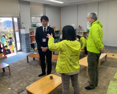 市長が施設を視察しており、2人のスタッフから話を聞いているようす