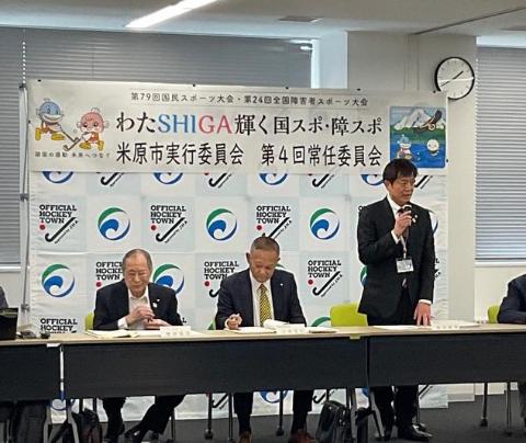 国スポ・障スポ米原市実行委員会第4回常任委員会と書かれた文字、ホッケータウンのロゴ、米原市のロゴのパネルの前で、マイクを手に持ち挨拶されている市長の写真