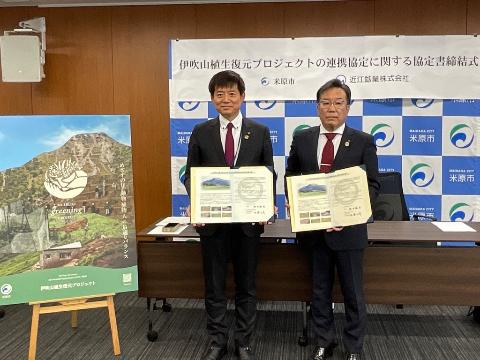 市長と近江鉱業の方とで協定書を手に持っている写真