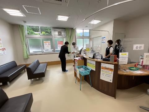 吉槻行診療所を視察いたしました。受付カウンターにてスタッフと話を交わしている写真
