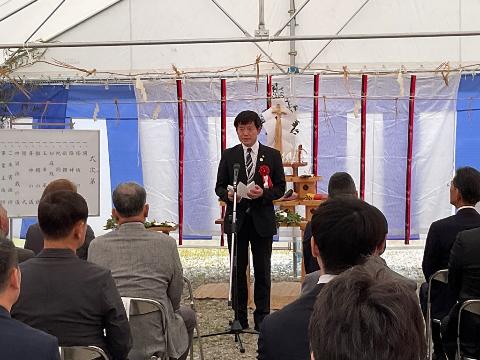 日本再生可能エネルギー株式会社 米原太陽光発電所竣工式に出席いたしました。パイプ椅子に座っている多くの人の前で挨拶をしている市長の写真