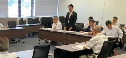 会議室で、長机で囲んで、正面あたりの場所で立ってお話されている市長の写真