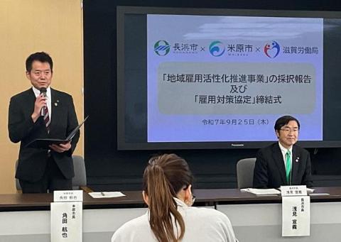 テレビモニターが後ろにあり、バインダーを片手にお話されている市長の写真