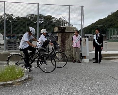 自転車で登校する生徒達に挨拶する市長の写真