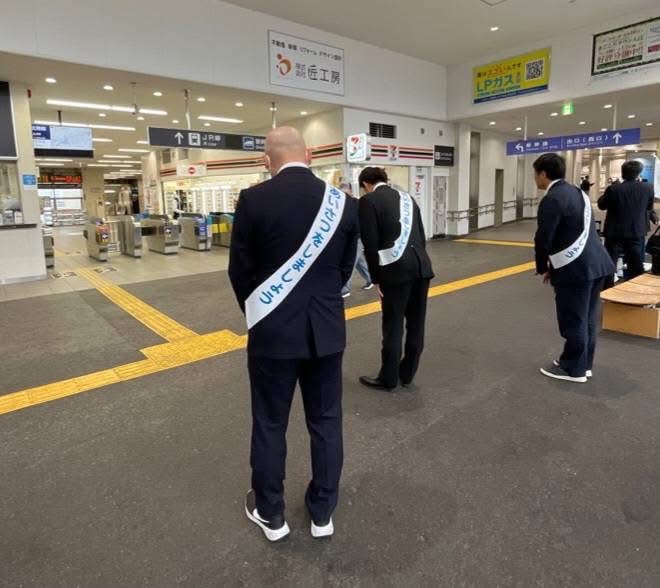 改札口前であいさつ運動を行っているようす