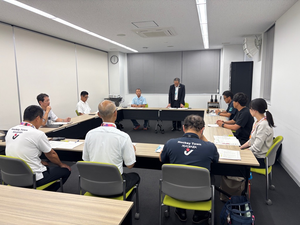 会議室にて、長机で囲んで会議しているようす。1枚目とは違うアングルの構図。