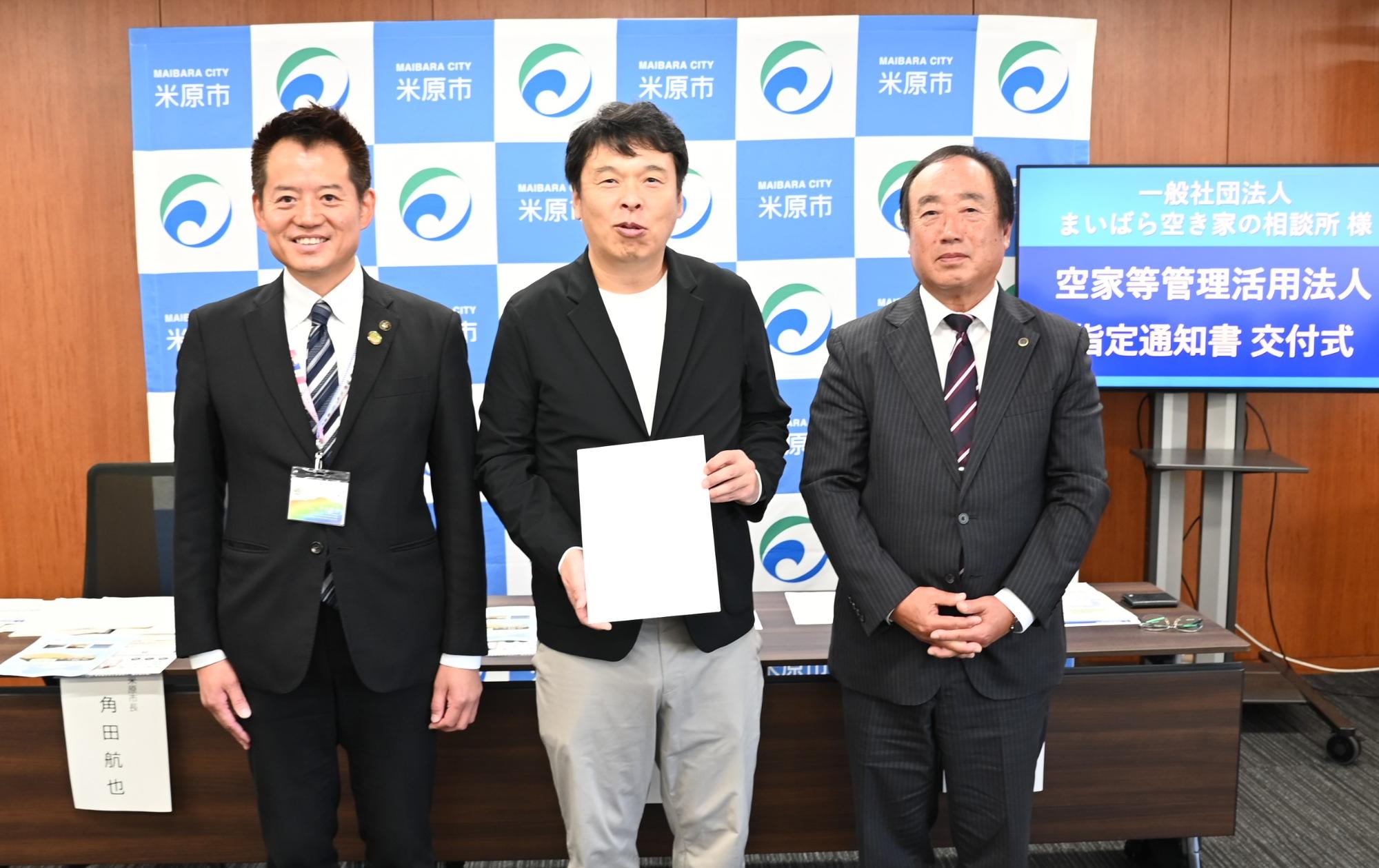 市長と、指定通知書を持つまいばら空き家の相談所代表2人の写真