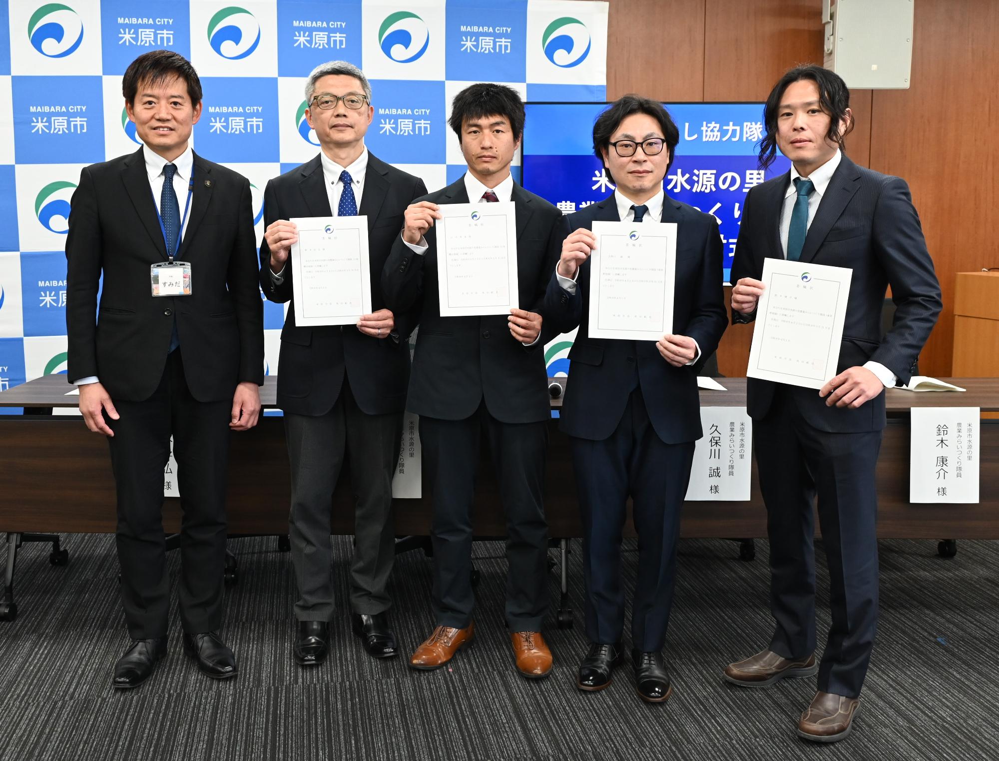 委嘱状をもつ隊員4人と角田市長の写真