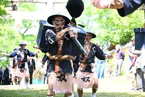 武家奴振りで荷を担ぐ男性の様子