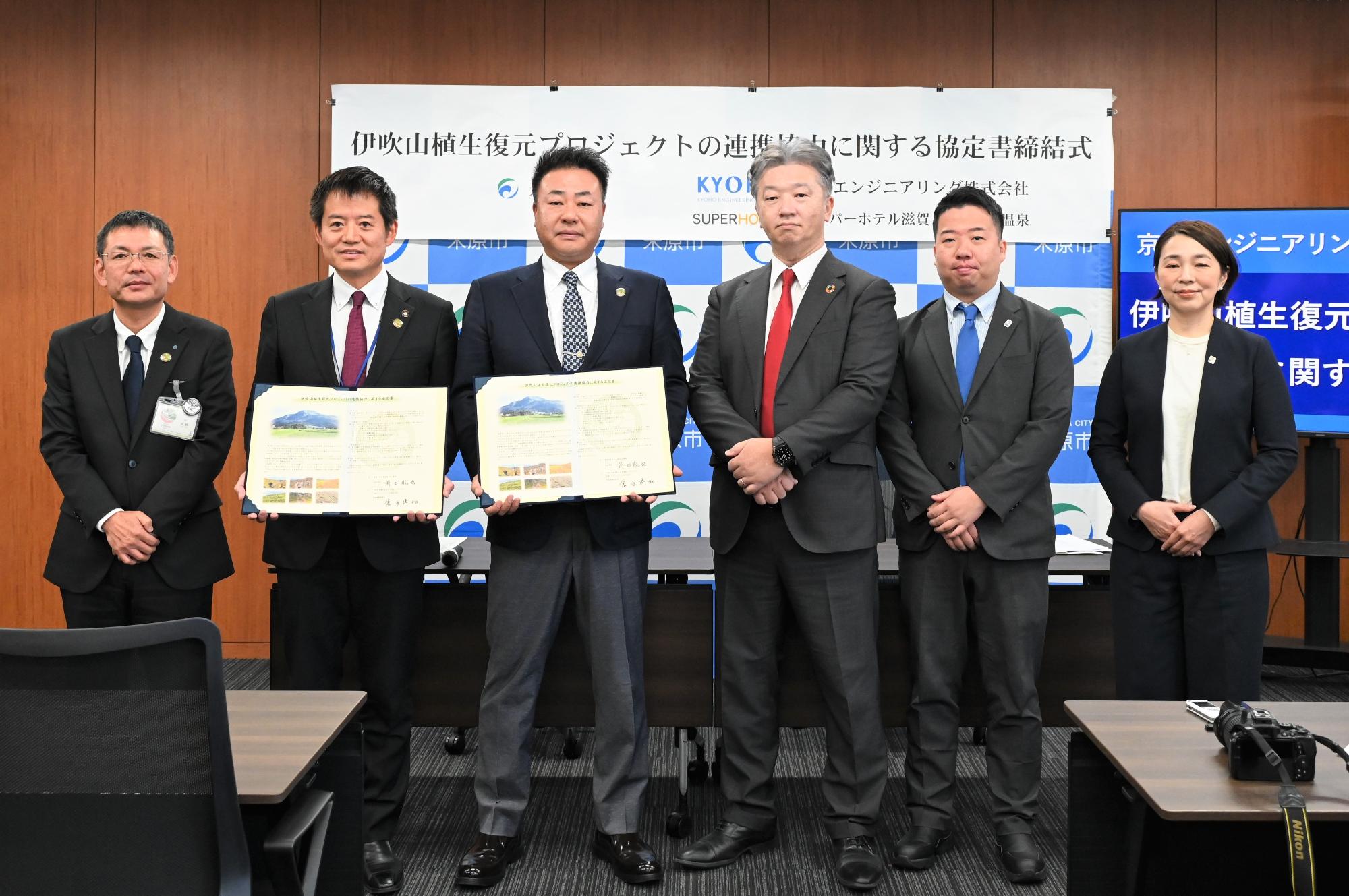 京豊エンジニアリング株式会社との連携協定締結式の様子。中央に市職員と会社の方が集まって撮影されている。左側から2番目に市長、その次に京豊エンジニアリング株式会社の方がそれぞれ協定書を手に持っている写真。