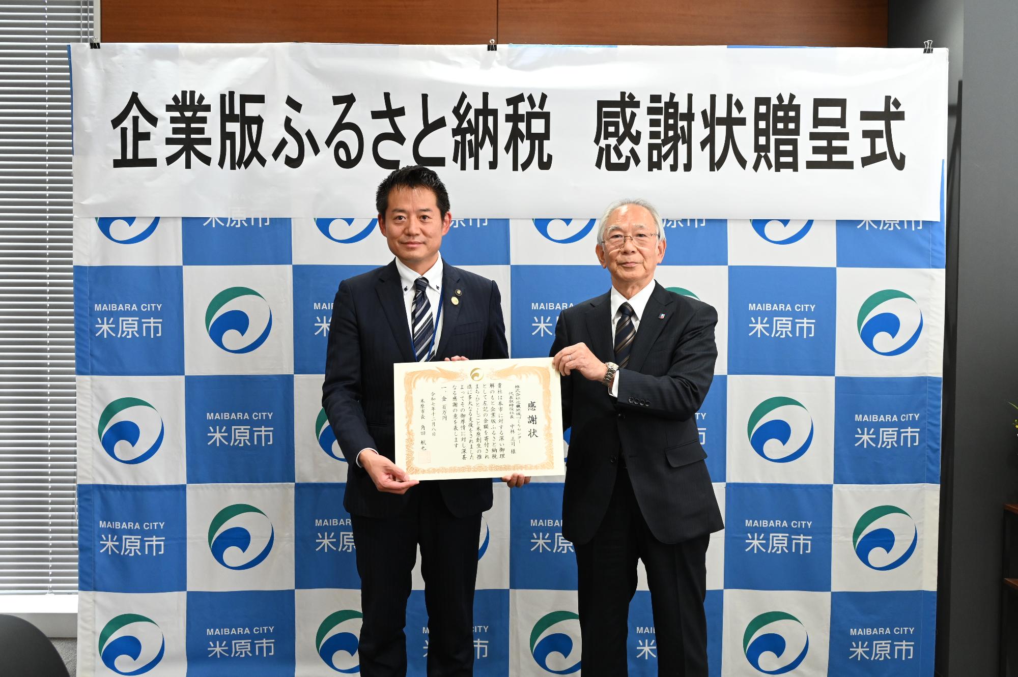 感謝状贈呈式で角田市長が左側、株式会社近畿地域づくりセンターが右側で感謝状を持って撮影された写真