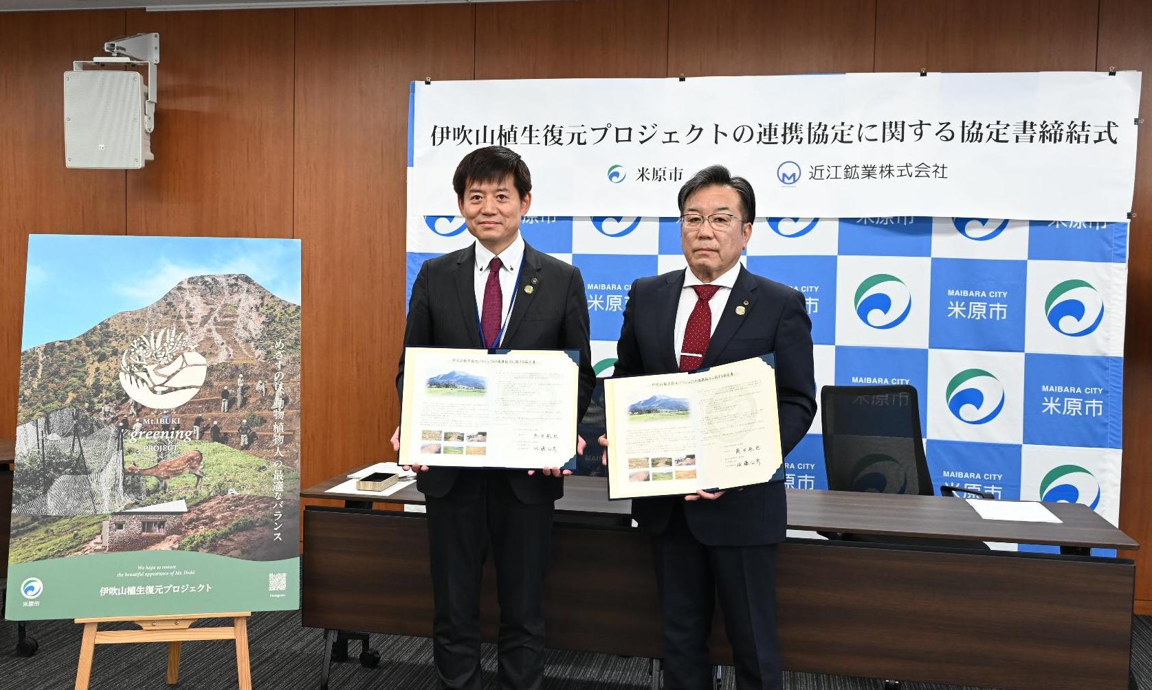 近江鉱業株式会社との連携協定締結式の様子。左側から市長、近江鉱業株式会社の方がそれぞれ協定書を手に持っている写真。