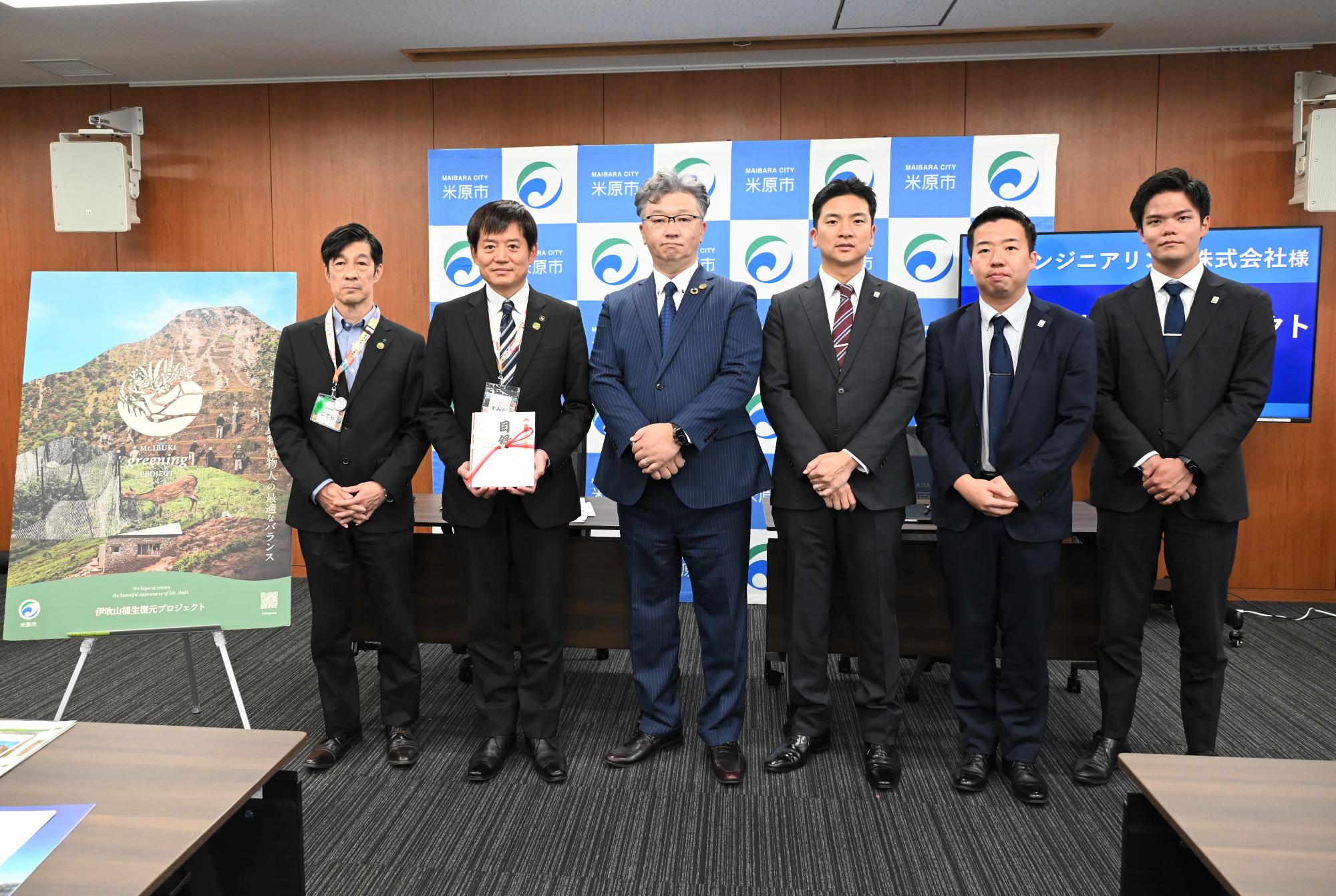左側から順に、市職員、その次は市長、その次に京豊エンジニアリング株式会社の方が4人立っている写真。