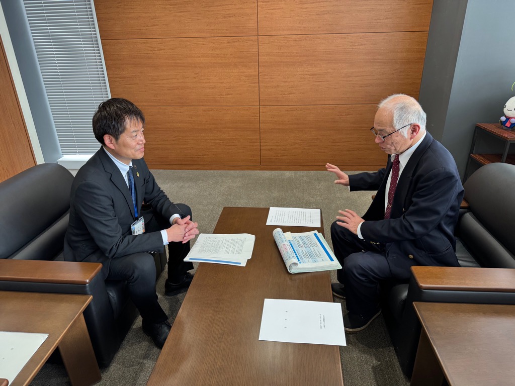 下水道事業審議会会長と市長との懇談の場面。会長と市長が机に向かい合って座り、審議会で出た意見を伝えている様子。