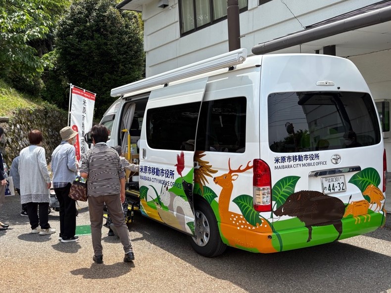 移動市役所地域巡回の様子2。市民が移動市役所の車に乗ろうとしているようすの写真