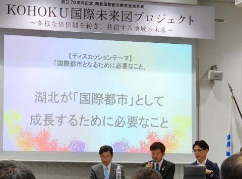後ろにプロジェクタースクリーンがあり、その前の机で左から男性、市長、男性の順にディスカッションされているようす