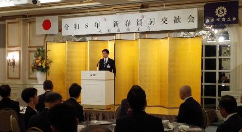 壇上にて挨拶をされている市長の写真。後ろには金屛風がある。