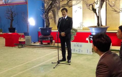 挨拶をしている市長の写真。後ろには盆梅が飾られている。