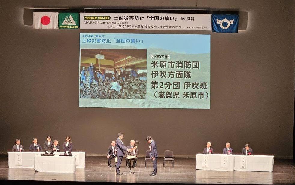 壇上で表彰を行っているようすの写真。