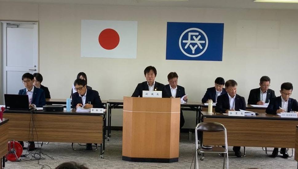 会議室にて、発言席に着席しお話されてる市長の写真