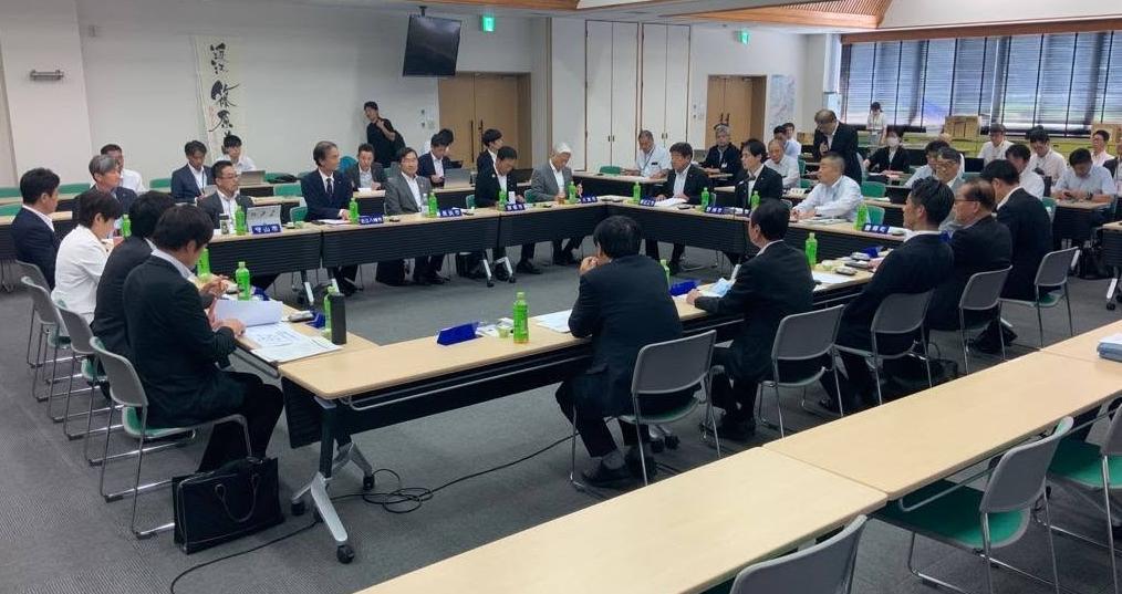 会議室にて、長机で囲んで会議しているようす