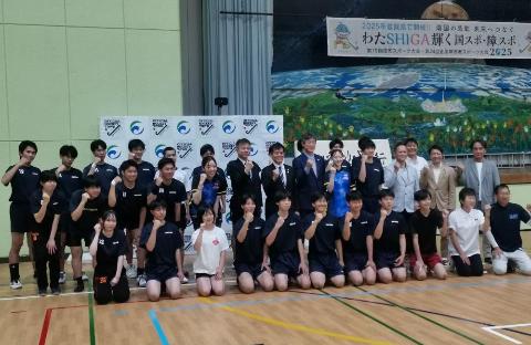 体育館で東レアローズ滋賀の選手たちと集合写真を撮影しているようす