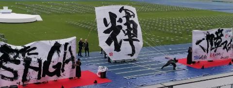 書道部パフォーマンスのようす。大きく書かれた文字を凧揚げのように掲げているようす。