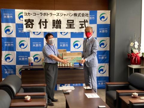 コカ・コーラボトラーズジャパン株式会社寄付贈呈式で飲料を受け取る市長