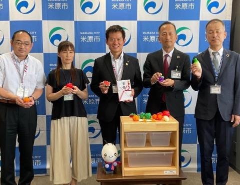 Daigasグループの皆さまと、ミニサイズの野菜のオブジェを手に持って写真撮影