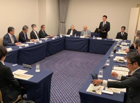 会議室にて長机で囲んで、立ってお話されている市長の写真