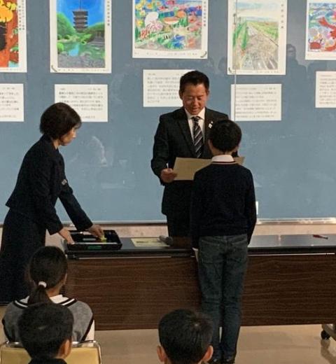 受賞者の子どもたちに賞状をおくっているようす