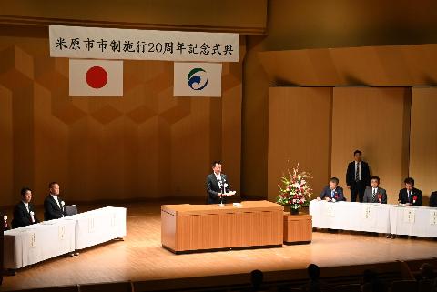 ホール内のステージ上で挨拶する市長の写真