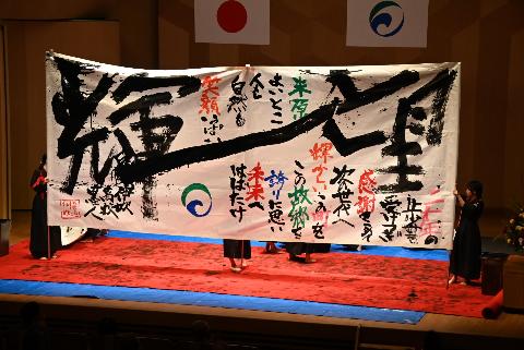 オープニングアトラクションでお披露目した伊吹高校書道部の作品。大きな輝と望の文字が左右にあり、その間には米原はよいとこ人も自然も笑顔いっぱい等と書かれている。